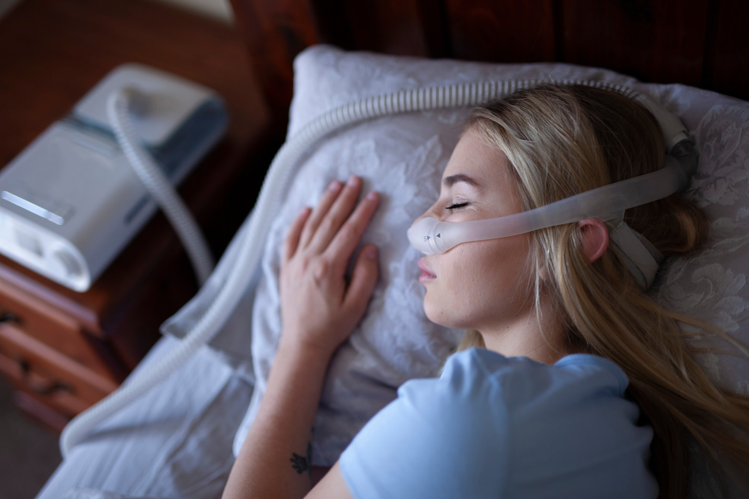 Mujer con apnea del sueño durmiendo con CPAP