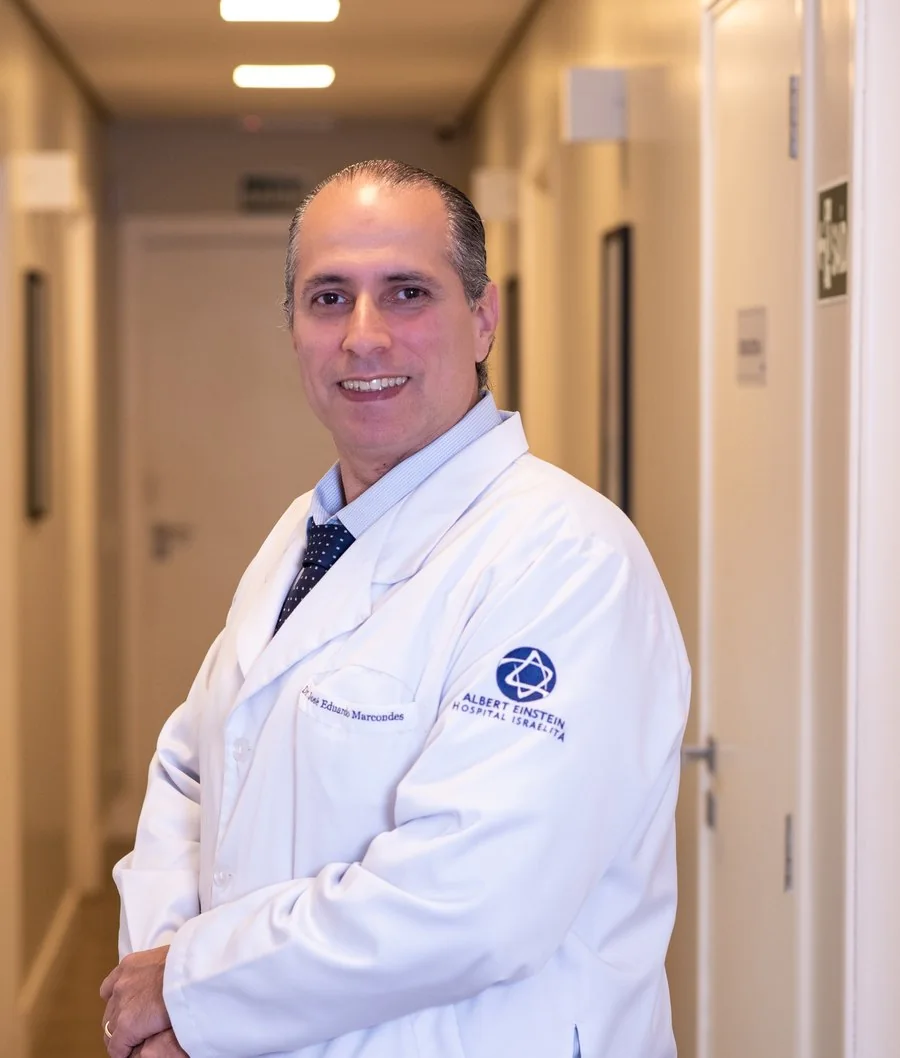 Dr. José Eduardo Marcondes, physician and otolaryngologist (ENT), in a white coat in the corridor of Hospital Albert Einstein